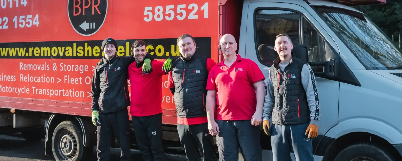 Five Bradway Premier Removals crew members standing in front of a red removals lorry