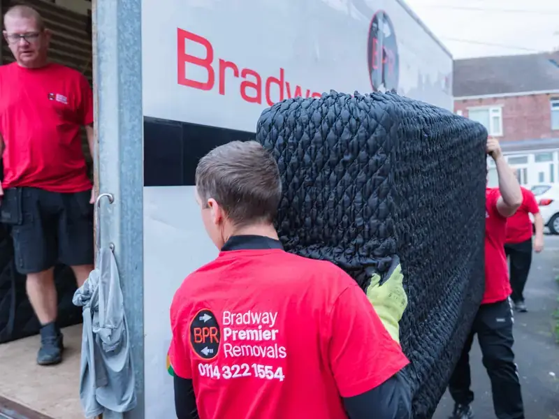 Bradway Premier Removals crew carrying protected furniture to the removals van during a house removal in Sheffield