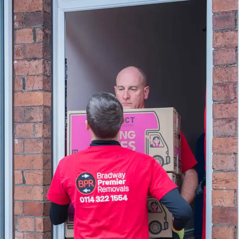 Bradway Premier Removals crew carrying a box through a front doorway during a house move