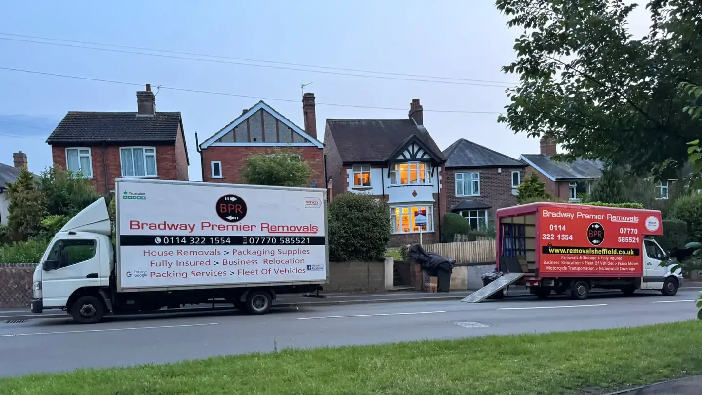 Two Bradway Premier Removals vans parked outside detached houses ready for a house removal